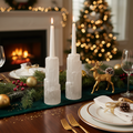 Pair of natural selenite crystal taper candle holders with white taper candles on holiday table