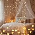 LED fairy light curtain with warm white string lights hanging on bedroom wall
